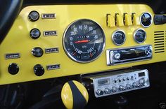 the dashboard of a yellow car with gauges and dash lights