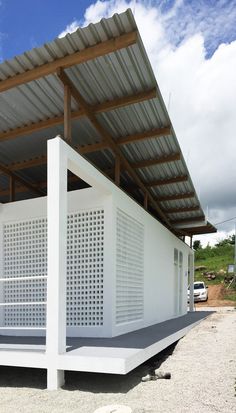 a white building with perfored roof on the side