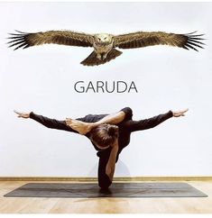 a person doing yoga in front of a wall with an owl on it's back