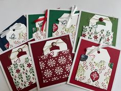 four christmas gift bags with tags attached to them, all decorated in red and green