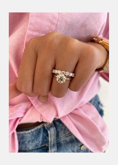 a woman's hand wearing a gold ring with three small diamonds on the band