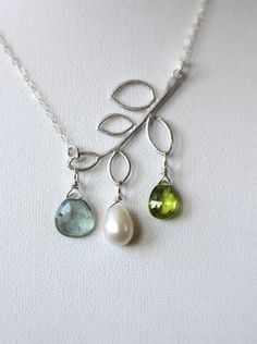 "Family Tree Necklace with choice of Three custom gemstones! My modern twist on the \"family tree\" necklace.  Your choice of three custom gemstones.  Shown here with Moss Aquamarine, Pearl and Peridot. Each stone is simply wired to the leaves on the silver branch pendant.  A beautiful and unique way to showcase the three people closest to your heart.  I hand select my gemstones, they are of the highest quality. Each stone is beautifully cut and faceted! The leaf is positioned on a slight angle and attached to shimmering sterling silver chain. Closure is a sterling silver lobster clasp accented by two tiny pearls to complete the clasp. Please click on the last photo to view all stone colors available. Leave a note at checkout with the three (3) stone colors you would like.   Chain Length: Necklace Family, Necklace Leaf, Necklace Mom, Bijoux Fil Aluminium, Family Tree Necklace, Necklace Birthstone, Tree Necklace, Mothers Necklace, Silver Tree