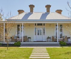 a white house with porches and steps leading to the front door