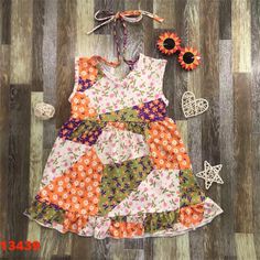 a dress made out of fabric with flowers on the bottom and an orange flower next to it