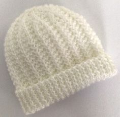 a white knitted hat laying on top of a table