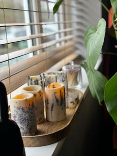 candles are sitting on a tray next to a window