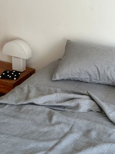 a bed with two pillows on it and a night stand next to the headboard