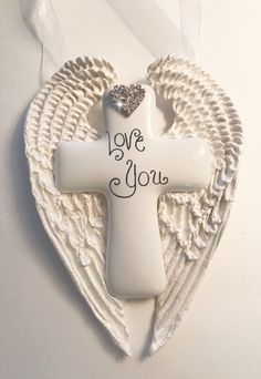 an angel's wing with the word love you written on it and a cross in the middle