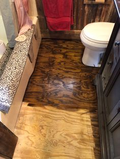 a bathroom with wood flooring and white toilet