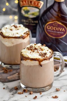 two glasses filled with hot chocolate and whipped cream