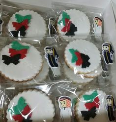 decorated cookies in the shape of people and christmas trees are displayed on plastic wrappers