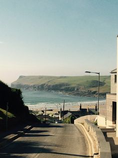 an empty street with the ocean in the background