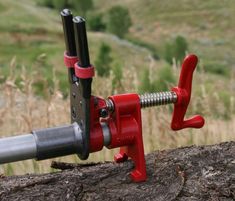 a close up of a red bike handle on a rock with a field in the background