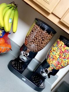 two blenders filled with cereal and bananas sitting on top of a counter next to other food