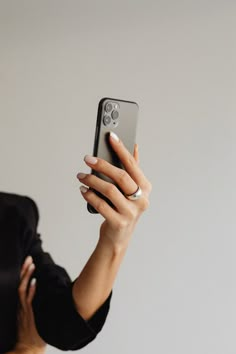 a woman taking a selfie with her cell phone in front of her face,