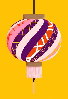 an ornament hanging from a string on a yellow background with pink and purple designs