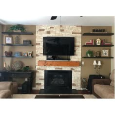 a living room with two couches and a television mounted on the wall above it