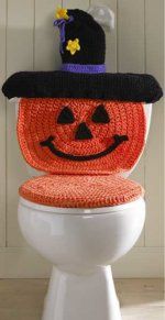 a white toilet with a knitted halloween pumpkin seat cover