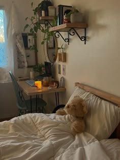 a teddy bear sitting on top of a bed next to a desk with a computer