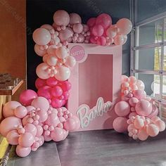 pink and white balloons are on display in front of a sign that says barbieo