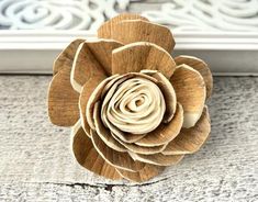 a wooden flower sitting on top of a window sill