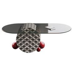 a skateboard shaped coffee table with red balls on the bottom and an oval glass top