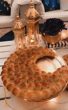 a large cake sitting on top of a table next to candles and other decor items