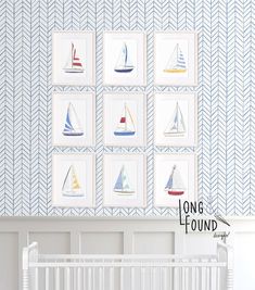 a baby's room with blue and white wallpaper, a crib and pictures on the wall