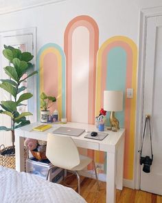 a white desk sitting in front of a colorful wall