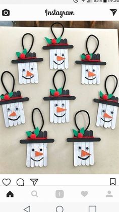 snowmen made out of popsicle sticks are hanging on the wall in front of an instagram