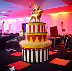 there is a circus themed cake on top of the table in this room with pink lighting