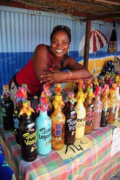 a woman standing behind a table covered in bottles