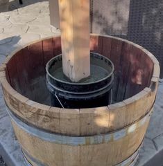 a wooden barrel sitting on top of a sidewalk