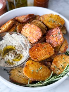 a white bowl filled with potatoes and dip