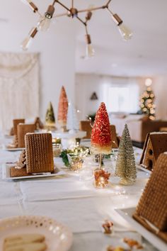 a table topped with lots of different types of christmas trees and small houses on top of it