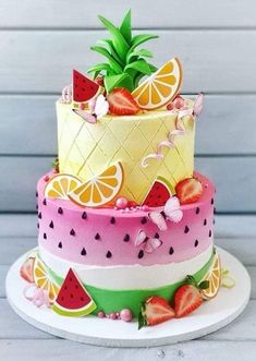 a multi layer cake decorated with fruit and pineapples