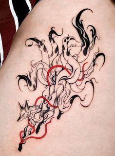 a woman's thigh with black and red tattoos on it