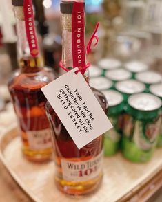 two bottles of alcohol are on a tray with labels attached to the bottles and tags in front of them