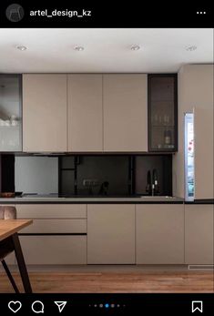 a kitchen with wooden flooring and cabinets in the middle, along with a dining table