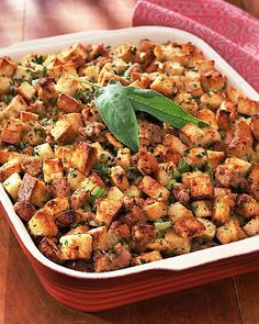 a casserole dish filled with stuffing and green leafy garnish on top