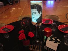 a table set up with plates, candles and napkins for an elvis birthday party