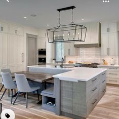 a large kitchen with an island in the middle and chairs at the table on the other side