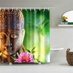 a shower curtain with a buddha head and pink flower in front of green bamboo leaves