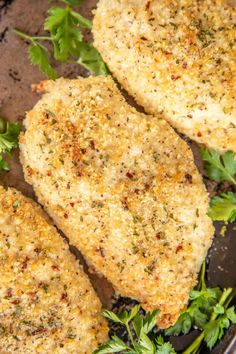 two chicken patties in a skillet with parsley