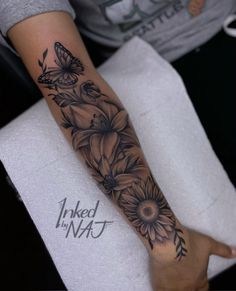 a woman's arm with flowers and butterflies on it