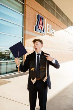 a man in a suit and tie holding up a book