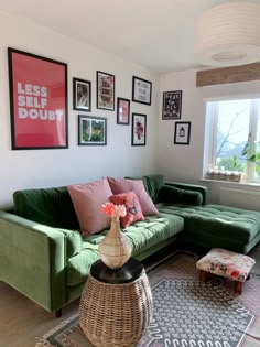 a living room with green couches and pictures on the wall