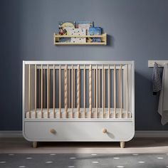 a baby's room with blue walls and white furniture