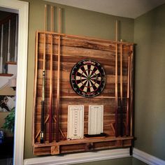 a dart board mounted on the wall with darts and other items in front of it