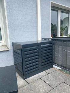 an outside view of a building with some windows and a black grill on the ground